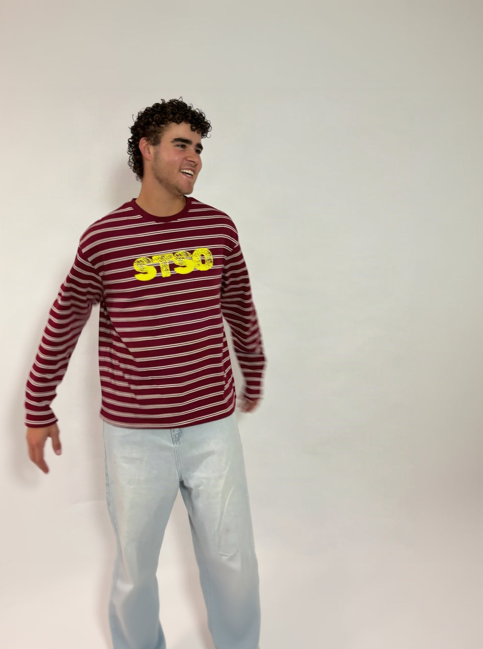 Gestreepte longsleeve bordeaux met gele STSO van 72.71 Clothing – voorkant, gedragen door een mannelijk model met een lichte jeans