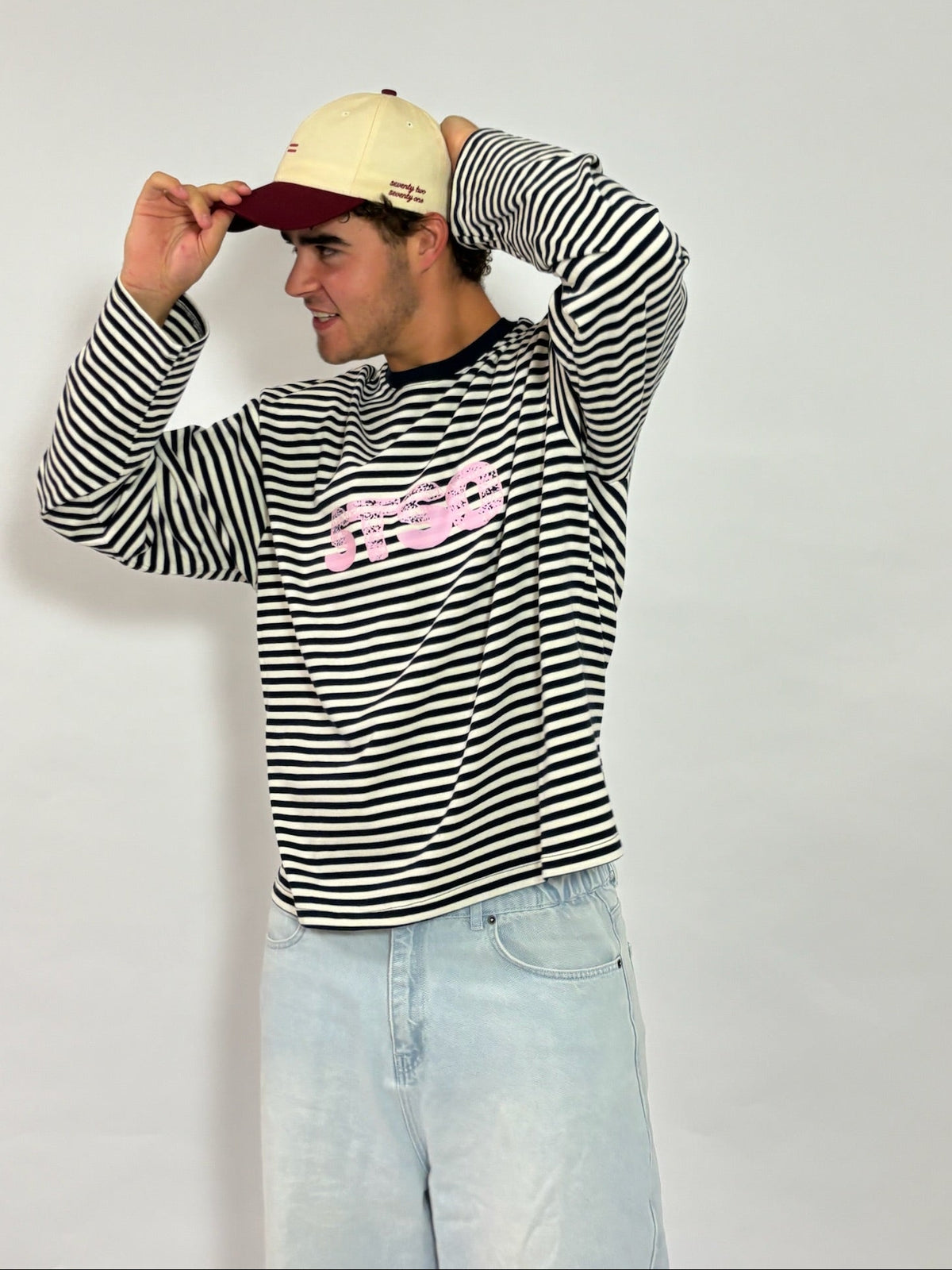 Cap crème met bordeaux klep van 72.71 Clothing – gedragen door een mannelijk model met een gestreepte longsleeve