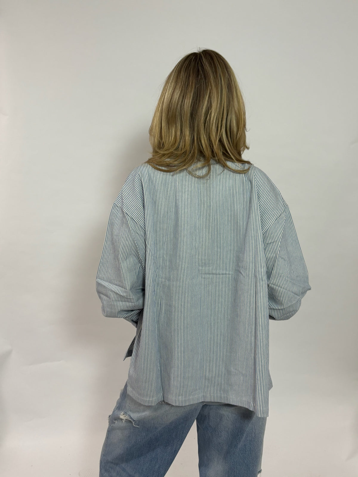 Gestreept overshirt lichtblauw met borduursel van 72.71 Clothing – achterkant, iets oversized gedragen met een lichte jeans