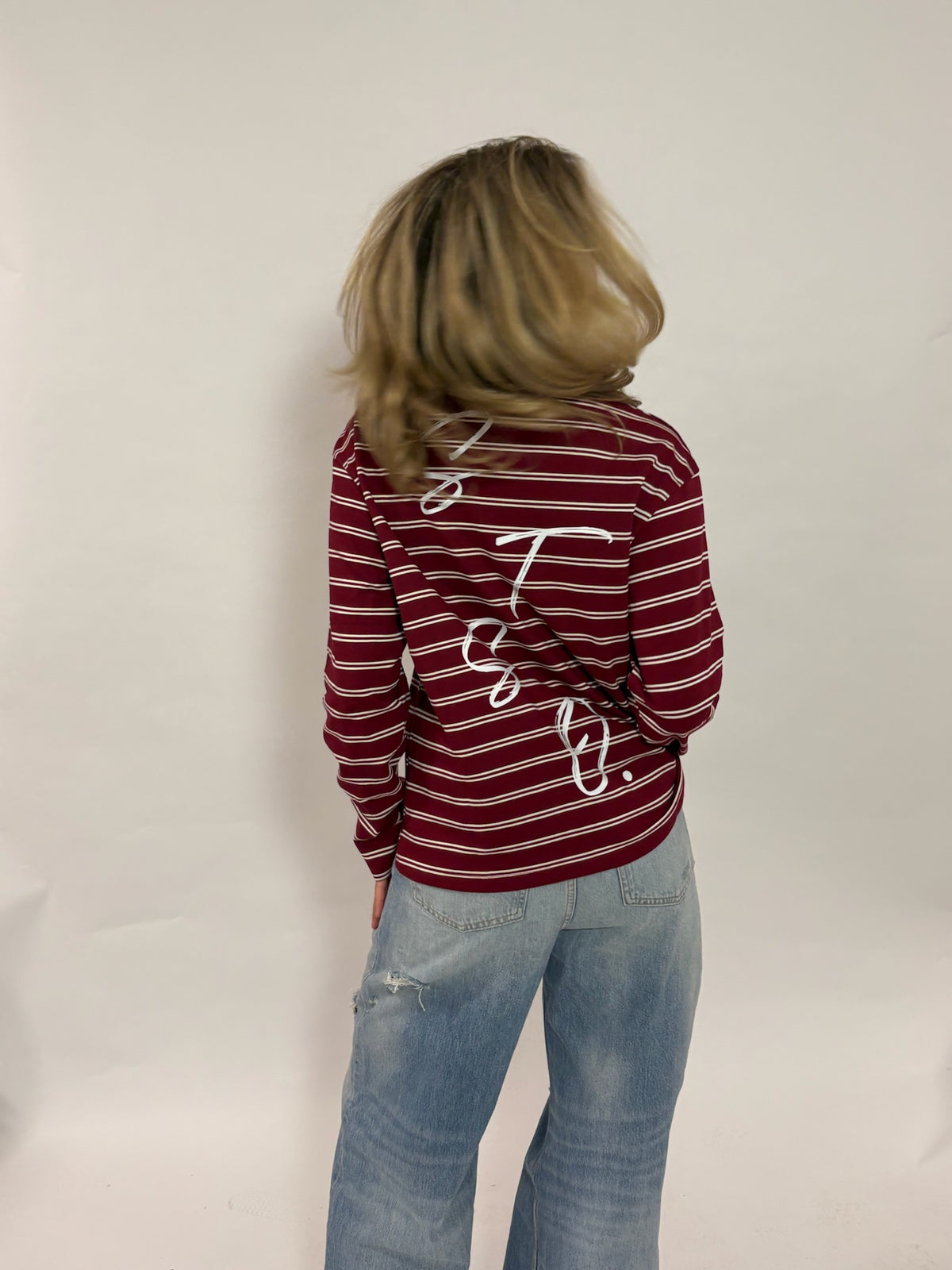 Gestreepte longsleeve bordeaux – Circle of Friends van 72.71 Clothing – achterkant, gedragen door een vrouwelijk model met een lichte jeans