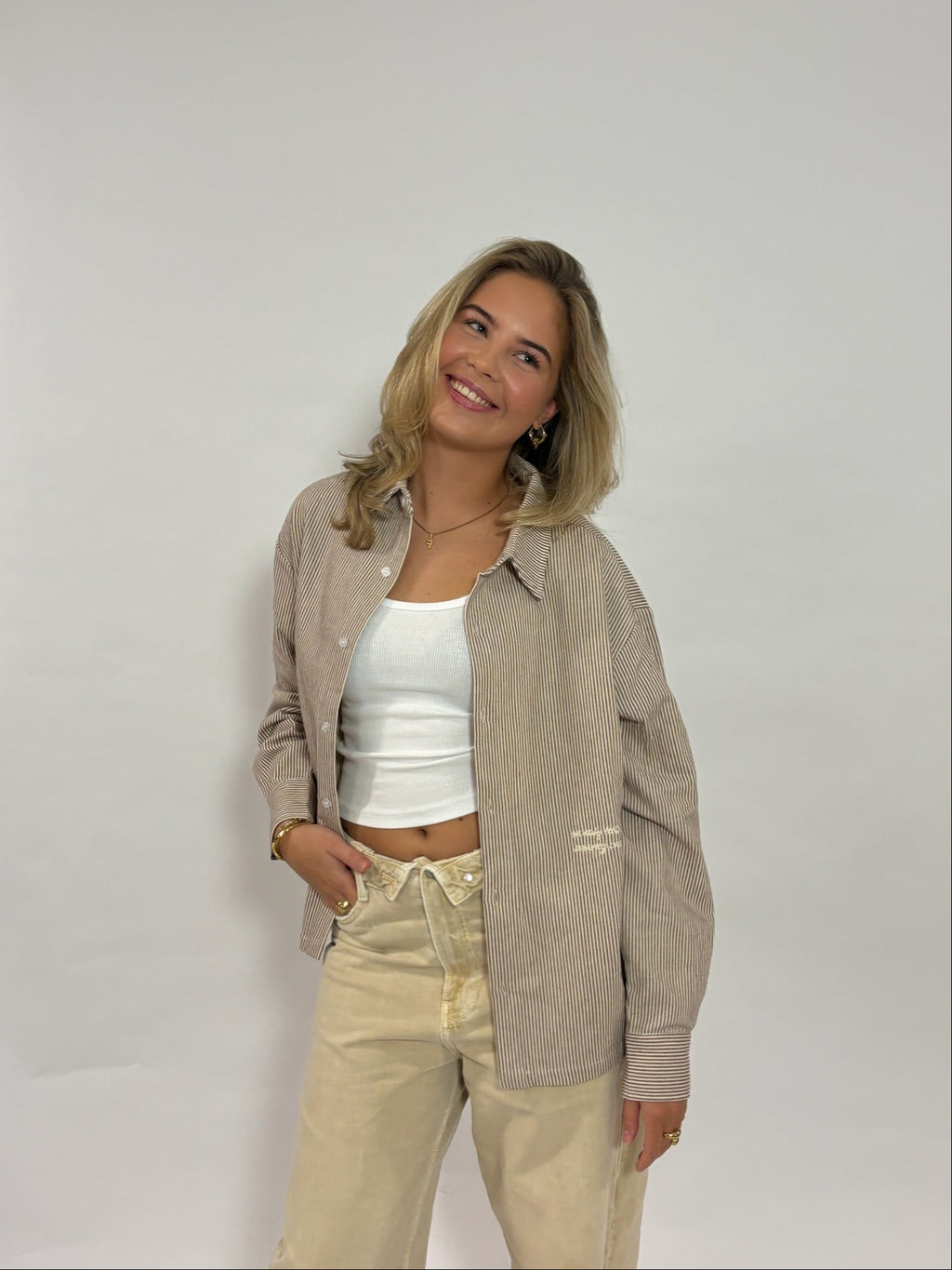 Gestreept overshirt donkerbruin met borduursel van 72.71 Clothing – open gedragen door een vrouwelijk model over een wit topje