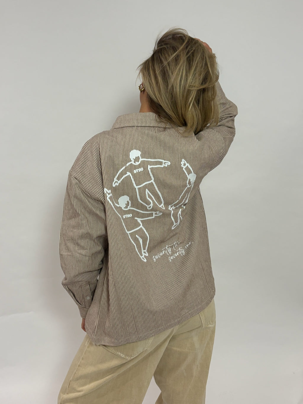 Gestreept overshirt donkerbruin met rugprint van 72.71 Clothing – achterkant met de Circle of Friends-tekening, gedragen door een vrouwelijk model