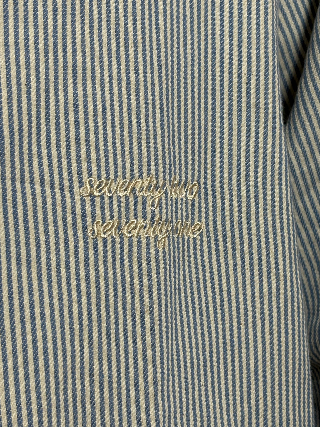 Gestreept overshirt lichtblauw met borduursel van 72.71 Clothing – close-up van het borduursel "seventy two seventy one" op de borst