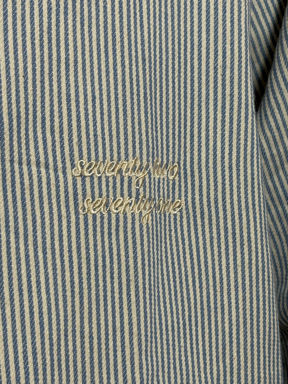 Gestreept overshirt lichtblauw met borduursel van 72.71 Clothing – close-up van het borduursel "seventy two seventy one" op de borst
