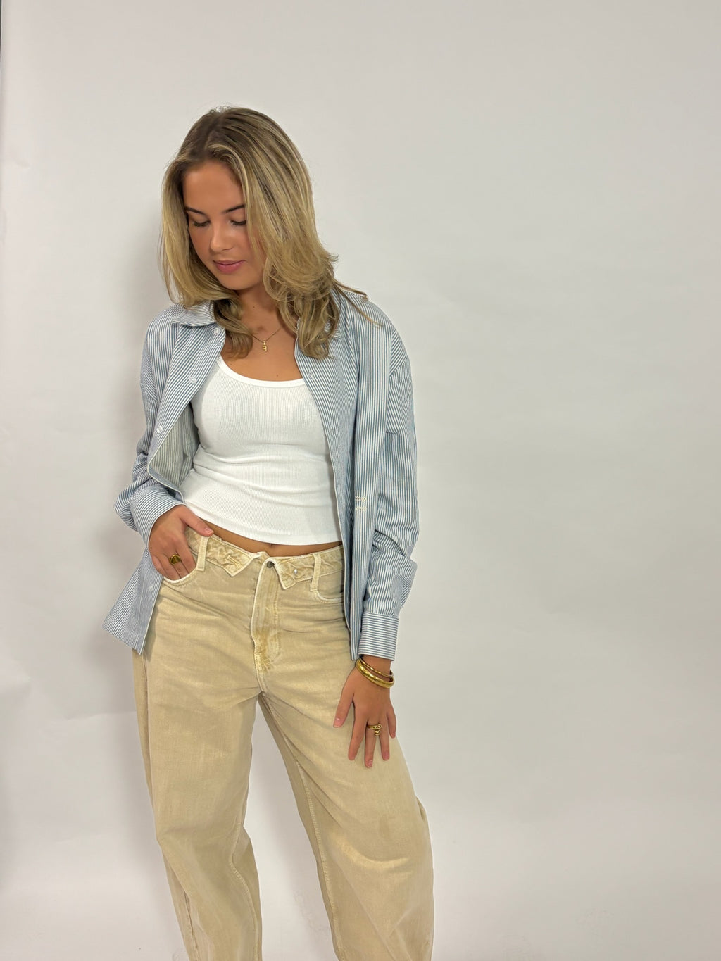 Gestreept overshirt lichtblauw – Circle of Friends van 72.71 Clothing – open gedragen door een vrouwelijk model over een wit topje