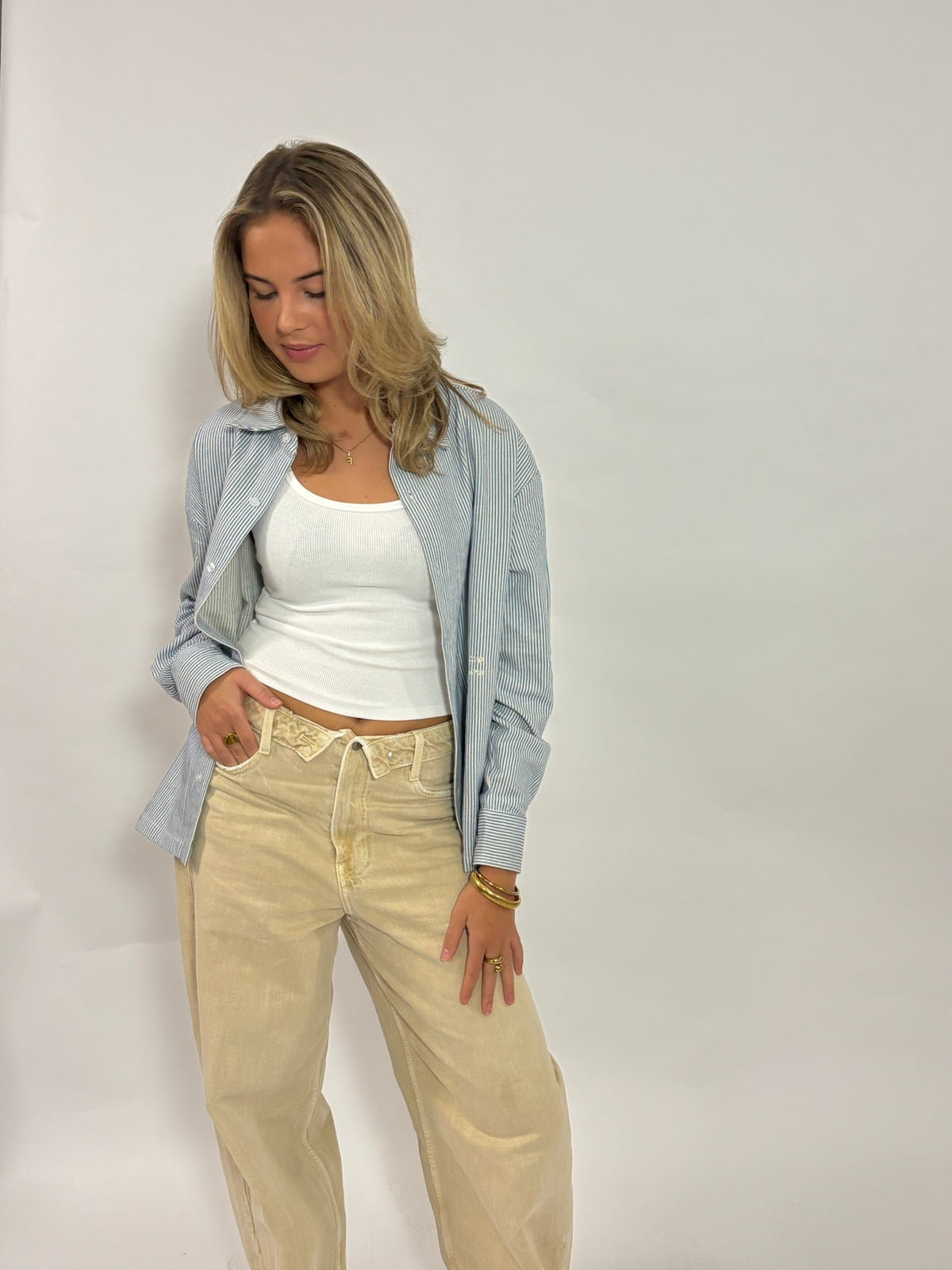 Gestreept overshirt lichtblauw – Circle of Friends van 72.71 Clothing – open gedragen door een vrouwelijk model over een wit topje