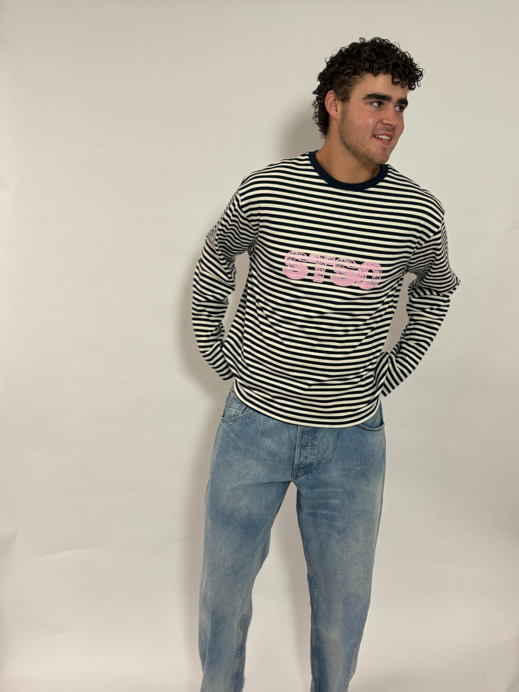 Gestreepte longsleeve navy met roze STSO van 72.71 Clothing – voorkant, gedragen door een mannelijk model met een lichte jeans