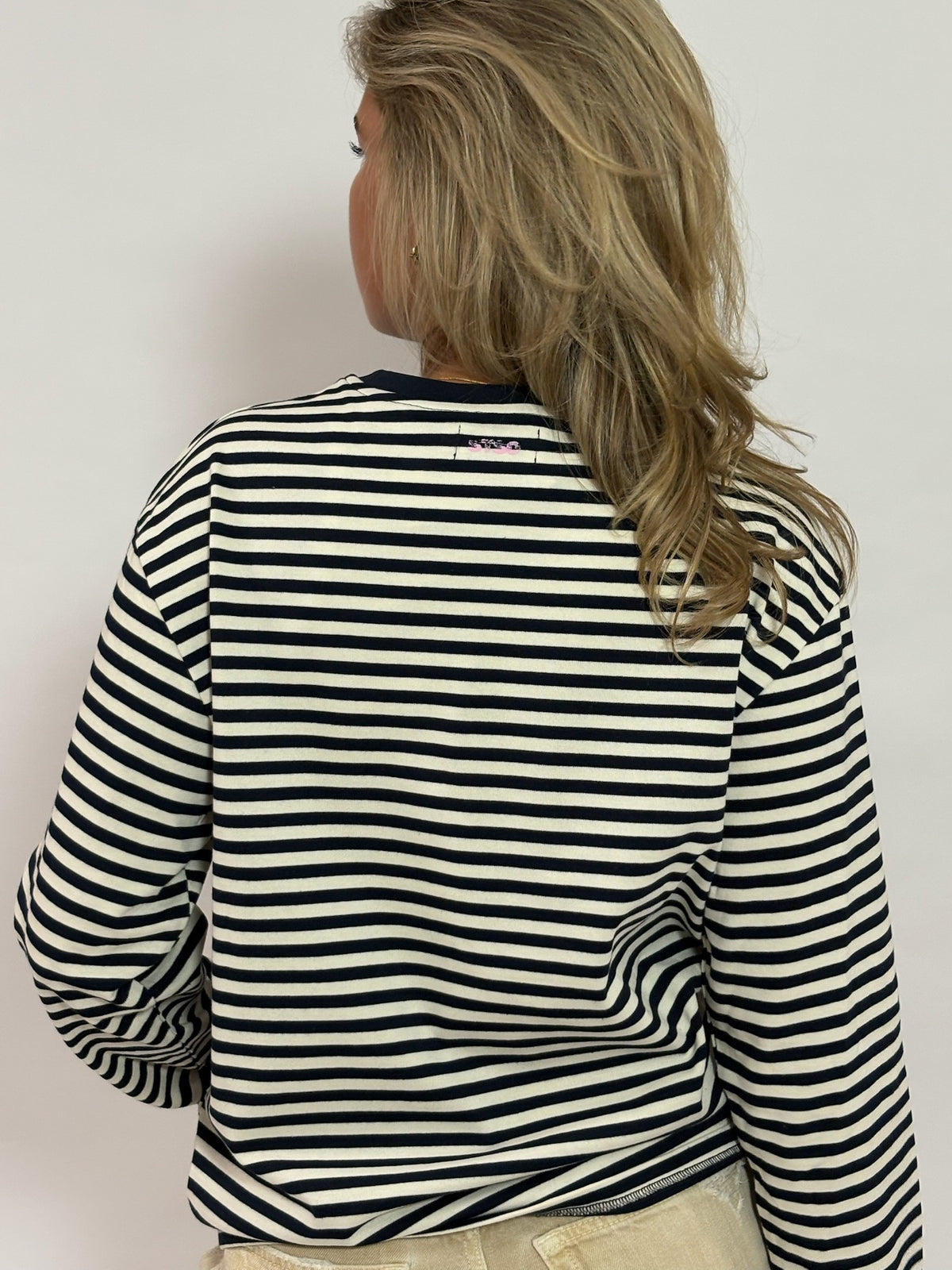 Gestreepte longsleeve navy met roze STSO van 72.71 Clothing – achterkant, gedragen door een vrouwelijk model